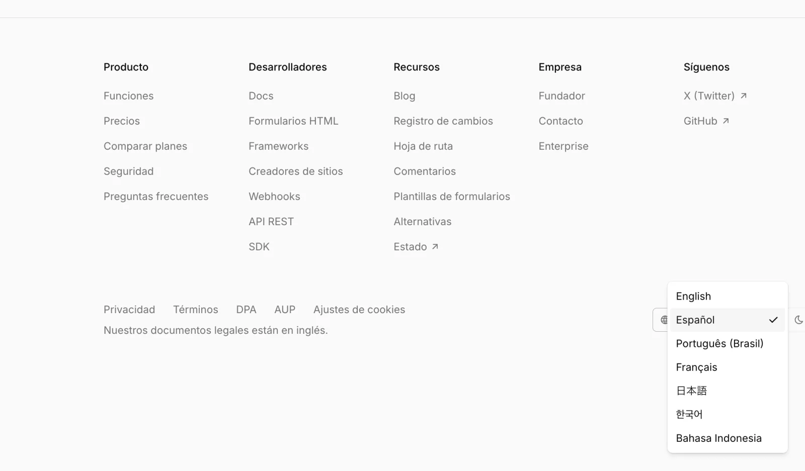 The site footer in Spanish with the language menu open, listing all seven languages.